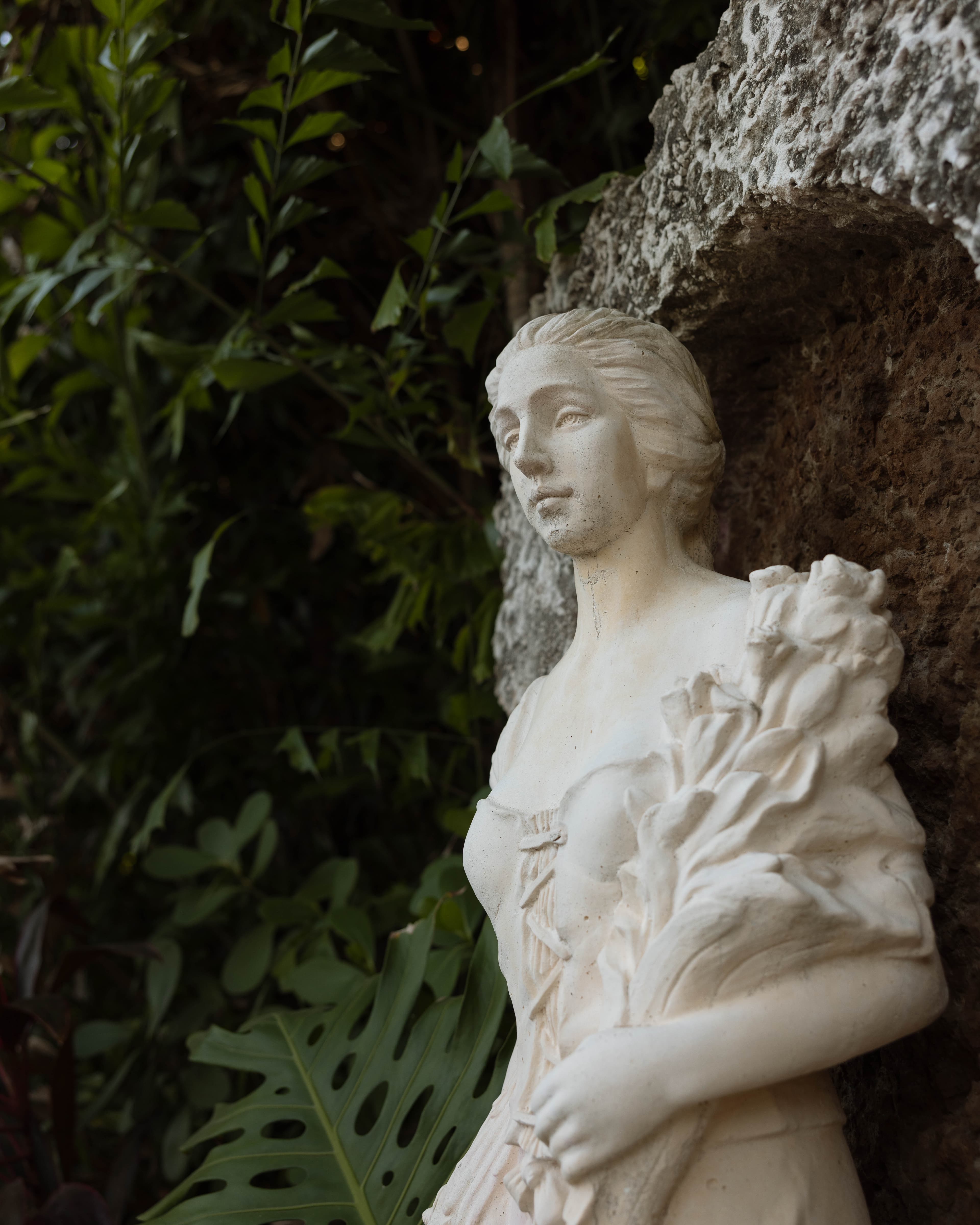 Statue detail among tropical foliage