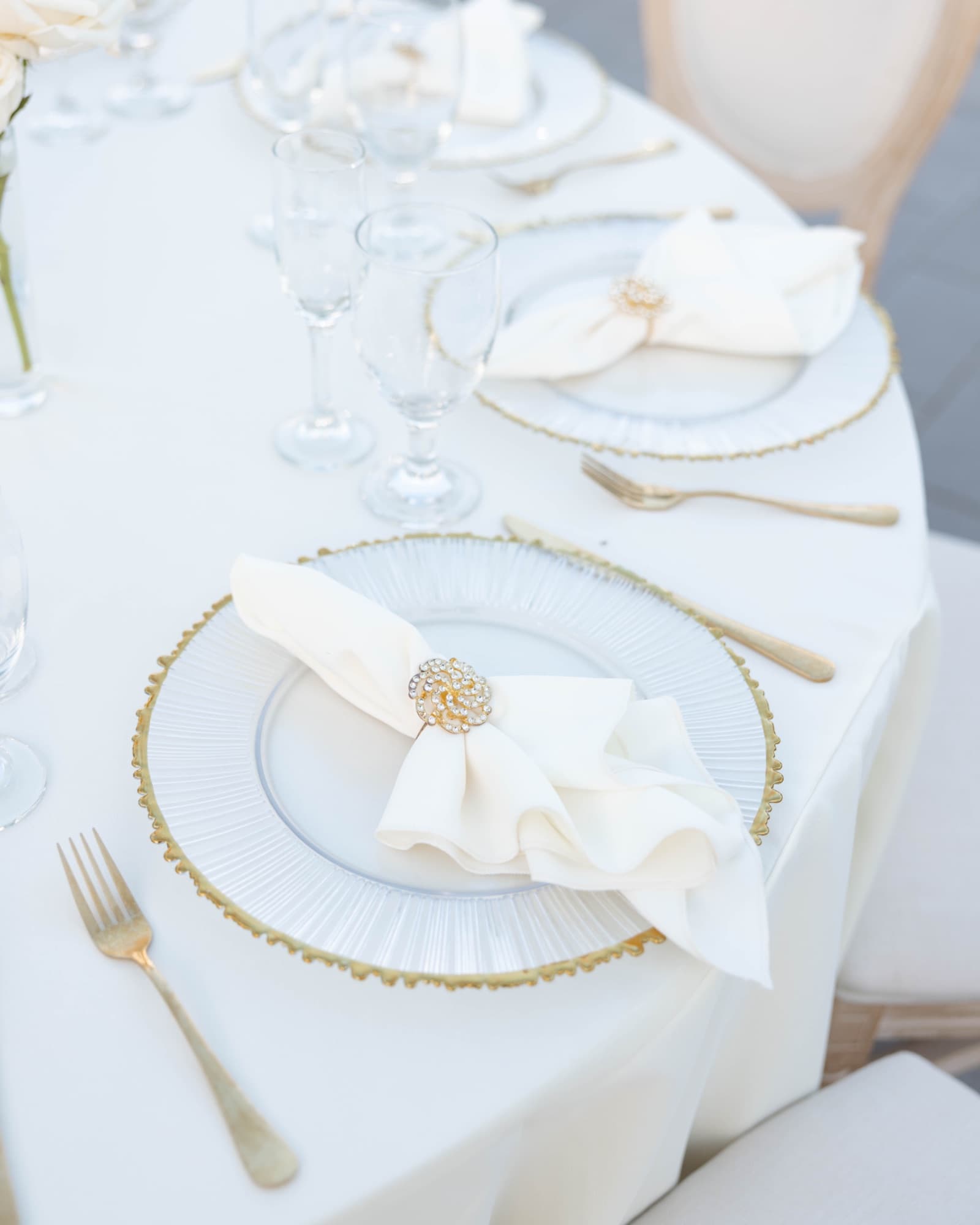 A place setting with gold flatware and a beaded charger — The Glass Venue wedding venue, Miami, Florida